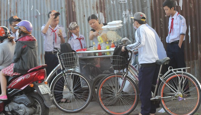 Học trò và những bữa ăn “công nghiệp” Học sinh Trường THCS Hoàng Hoa Thám phải mua bánh mì, xôi… ngay tại cổng trường ăn cho kịp giờ học buổi sáng. Ảnh: Ngô Đào
