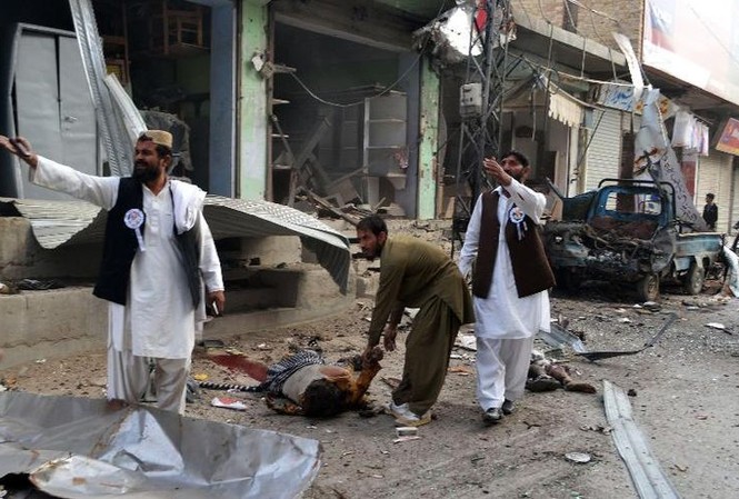 Tấn công xe buýt ở Pakistan, 9 người thương vong Cảnh sát Pakistan đứng bên ngoài chiếc xe buýt chở các nạn nhân của vụ tấn công. Ảnh: AFP.
