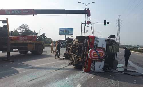 Xe khách chở 20 người đi đám tang gặp nạn Xe khách lật nghiêng sau va chạm. Ảnh: Lam Sơn.