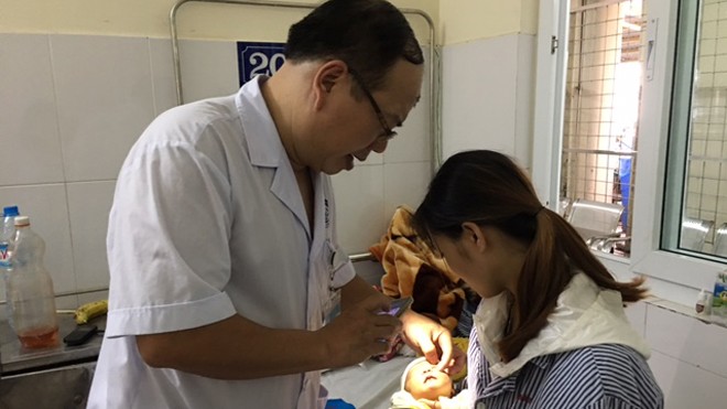 Bé gái 15 ngày tuổi loét giác mạc vì mẹ nhỏ sữa vào mắt Bác sĩ Hoàng Cương khám mắt cho cháu Đinh Phương Thảo. Ảnh: Đỗ Hợp