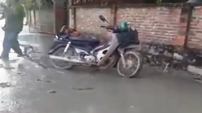 Người đàn ông đi xe máy cày nát đường bê tông mới làm Hiện trường vụ việc (ảnh chụp từ clip)