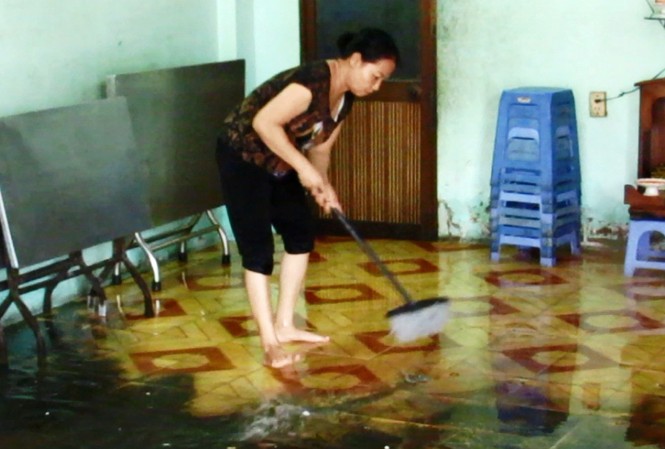 Mưa lớn giữa trưa, người Sài Gòn bì bõm tát nước trong nhà Dân bì bõm tát nước ngập tràn vào nhà.
