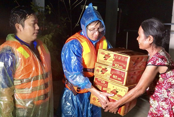 Đội mưa, băng lũ cứu trợ dân trong đêm Bí thư Tỉnh đoàn Đặng Minh Thảo trao quà cho người dân thôn Điền An, xã Nghĩa Điền, huyện Tư Nghĩa trong đêm lũ.
