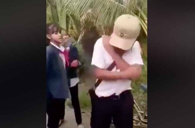 Nhóm nữ sinh vây đánh hội đồng nam sinh lớp 8 Nam sinh H chỉ biết ôm đầu chịu trận (Ảnh cắt từ clip).