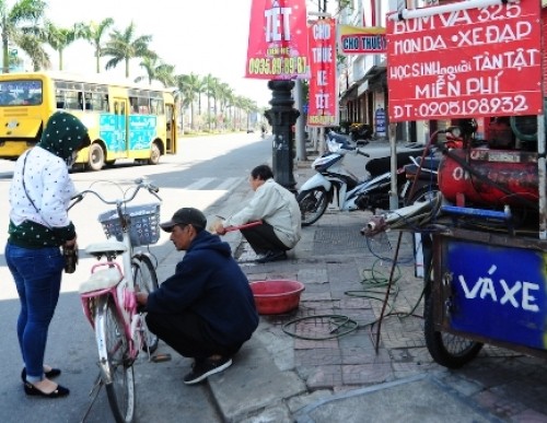 Đầu xuân gặp người vá xe miễn phí cho học sinh Anh Trần Viết Hùng đang bơm xe cho cháu Trương Anh Thư trưa mùng bốn Tết.