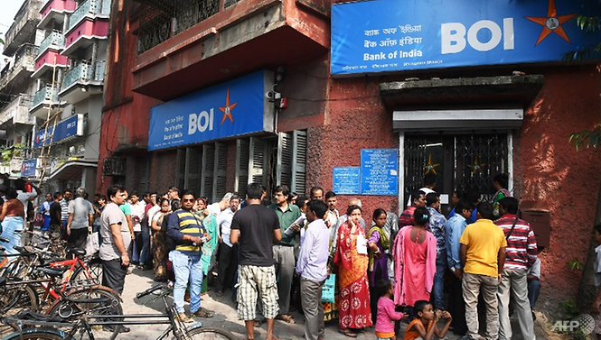 50 năm lịch sử máy ATM và xu thế giao dịch tiền mặt quay trở lại Người dân ở Kolkata xếp hàng bên ngoài ngân hàng để gửi tiền và đổi tiền mới 500 và 1.000 ngày 10/11/2016. Ảnh: AFP
