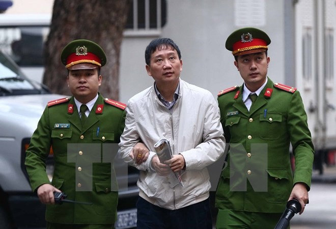 Một bị cáo vắng mặt trong phiên xử Trịnh Xuân Thanh tham ô Cảnh sát dẫn giải bị cáo Trịnh Xuân Thanh, nguyên Chủ tịch Hội đồng quản trị, Tổng giám đốc Tổng Công ty Cổ phần Xây lắp dầu khí Việt Nam - PVC đến tòa. (Ảnh: Doãn Tấn/TTXVN)