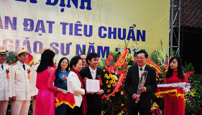 Thấy gì qua lễ công nhận giáo sư năm nay? GS trẻ nhất Phan Thanh Sơn Nam nhận chứng nhận chức danh và hoa do Phó Chủ tịch nước Nguyễn Thị Doan và Bộ trưởng Bộ GD&ĐT Phạm Vũ Luận trao tặng. Ảnh: Hồ Thu.