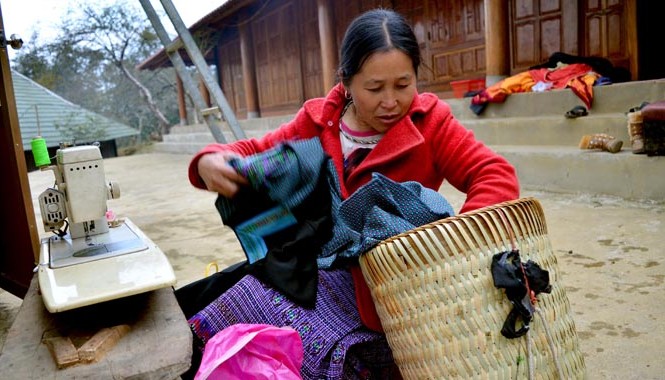 Năm 2015: Giảm tỷ lệ hộ nghèo xuống dưới 5% Mục tiêu Bộ LĐ, TB&XH xác định cho năm 2015 là tiếp tục đẩy mạnh các chính sách, dự án giảm nghèo. Trong ảnh: Người dân may áo mới cho con tại bản Pà Cò thuộc huyện Mai Châu, tỉnh Hòa Bình. Ảnh: Anh Tuấn.