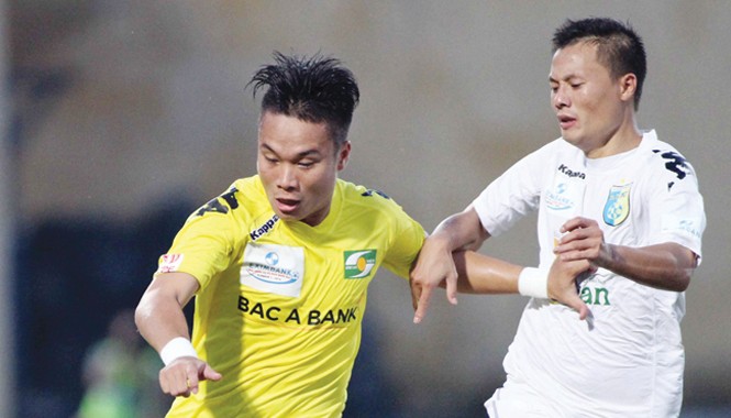 Hạ Hà Nội T&T, cầu thủ SLNA được thưởng nửa tỷ đồng SLNA (trái) tiếp tục khiến Hà Nội T&T ôm hận trên sân Vinh chiều qua. Ảnh: VSI.