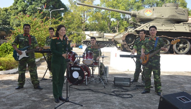 Bát cháo nên duyên Huy Sỹ (bìa phải) đệm đàn guitar cho vợ hát trong một buổi tập văn nghệ của đội.