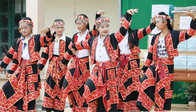 Cô dân quân Vị Xuyên, chàng trai Áo và điệu Kalinka Các em học sinh vui múa hát đón tủ sách mới. Ảnh: Trung Hiền.