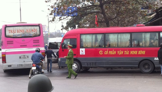 Xe rùa bò, vòng vèo bắt khách: Đi cửa “ngách”, cảnh sát bất lực? Xe khách dàn hàng ngang, đứng bắt khách trước cổng bến Giáp Bát sáng 13/2 nhưng cảnh sát chỉ đứng nhìn. Ảnh: Anh Trọng.