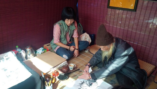 Tô màu, kẻ biển và ông đồ chạy sô TS Hán Nôm Cung Khắc Lược vừa hoàn thành bức thư pháp. Ảnh: Trung Dũng.