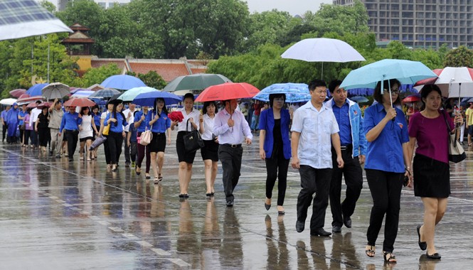 Từng dòng người đi trong thương nhớ… Người dân đội mưa xếp hàng vào lăng viếng Bác. Ảnh: Xuân Tùng.