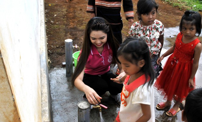 Khi người đẹp về buôn Bàn giao công trình nước sạch cho trường, trao tặng đồ chứa nước cho người dân.