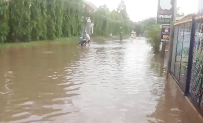 Dân lội nước đợi chính quyền xử lý Đường phố bị ngập úng nghiêm trọng.