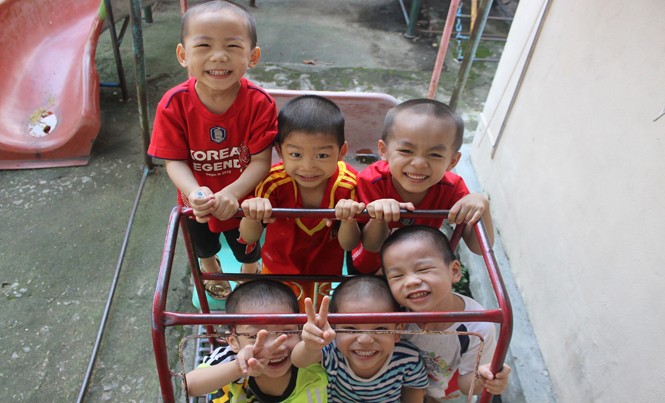 8 đứa trẻ mòn mỏi chờ cha mẹ Các em vui vẻ nô đùa sau giờ học.
