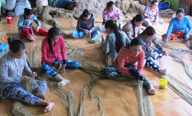 Vá lưới bên bờ biển Tây Chị em phụ nữ thị trấn cửa biển Sông Đốc tập trung vá lưới thuê cho chủ tàu.