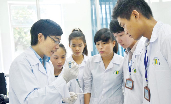 Nhà nông trẻ kiểu mới Lê Văn Tình (bìa trái) hướng dẫn sinh viên tại phòng thí nghiệm. Ảnh: Trường An.