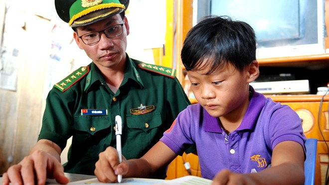 Những người cha đỡ đầu miền biên viễn Cán bộ Đồn Biên phòng Cửa khẩu Trà Lĩnh đến nhà kèm cặp em Hoàng Văn Truyền học bài.