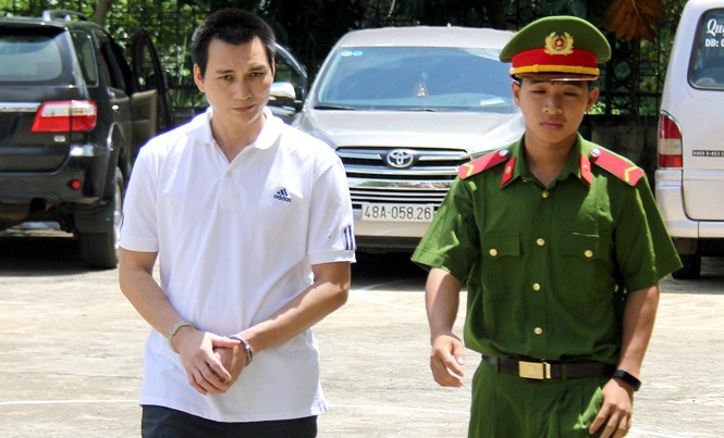Nguyên cán bộ công an lĩnh án 10 năm tù giam Bị cáo Hùng (áo trắng) bị dẫn giải tại phiên xét xử sơ thẩm.
