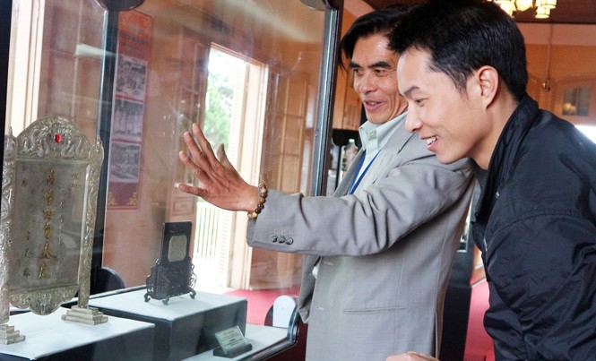 Hành trình lưu lạc 120 bảo vật triều Nguyễn - Kỳ 1: Viên cận thần tận trung Giám đốc bảo tàng (bên trái) nói về bức trấn phong “vạn thọ tứ tuần Đại Khánh”.