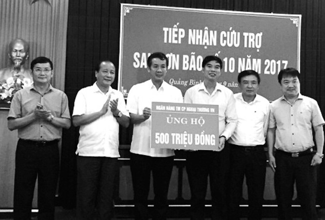 Vietcombank trao 1 tỷ đồng ủng hộ đồng bào miền Trung Đại diện Vietcombank, đồng chí Vũ Tiến Duật - Phó Bí thư thường trực Đảng ủy (thứ 3 từ phải sang) trao tượng trưng số tiền 500 triệu đồng giúp đồng bào tỉnh Quảng Bình khắc phục hậu quả bão lụt.