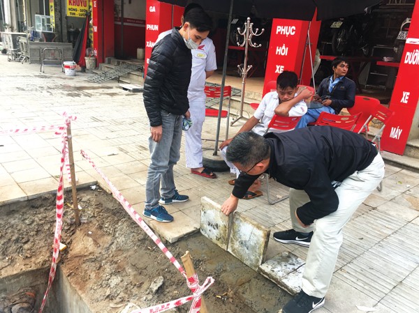 Cận cảnh 'phong trào' lát đá vỉa hè tại Hà Nội Đá lát trên vỉa hè tuyến phố Đền Lừ (Hoàng Mai) bị lật lên khá dễ dàng dưới sự chứng kiến của người dân. Ảnh: Trường Phong.