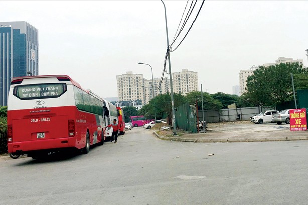 Bãi xe lậu hoành hành, đội trưởng Thanh tra “mất ghế” Ngoài xe trong bãi, các tuyến đường sau tòa nhà Keangnam đang là nơi đỗ thường xuyên của nhiều xe khách mang thương hiệu Kumho Việt Thanh. Ảnh: A.Trọng.