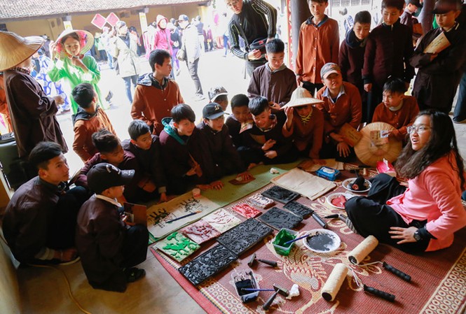 Tiết học giữa sân đình làng Chòng Học sinh hào hứng với tranh Đông Hồ. Ảnh: Nghiêm Huê.