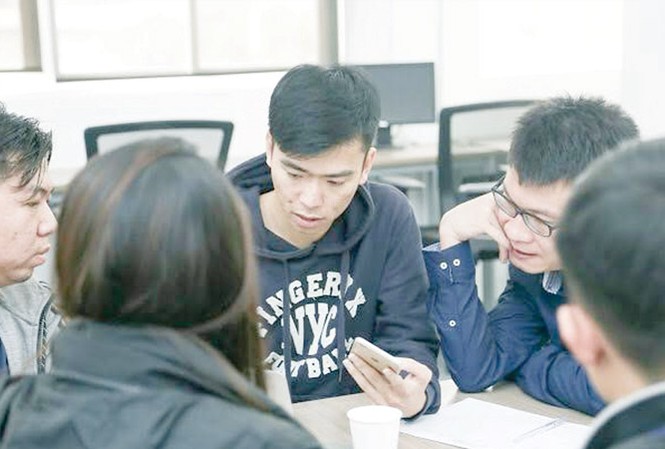 Đại 'Nami' và khát vọng toàn cầu Giáp Văn Đại (người cầm điện thoại) trao đổi công việc với các thành viên. Ảnh: NVCC.