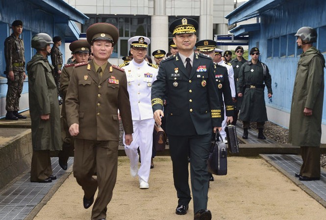 Hàn Quốc-Triều Tiên hội đàm quân sự Trung tướng quân đội Hàn Quốc Kim Do-gyun (phải) bước qua biên giới Hàn Quốc-Triều Tiên, bên cạnh là một sỹ quan Triều Tiên. Ảnh: AP.