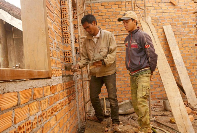 Từ phụ hồ thành chủ thầu Anh Y Noan hướng dẫn thợ mới vào nghề. Ảnh: H.T.