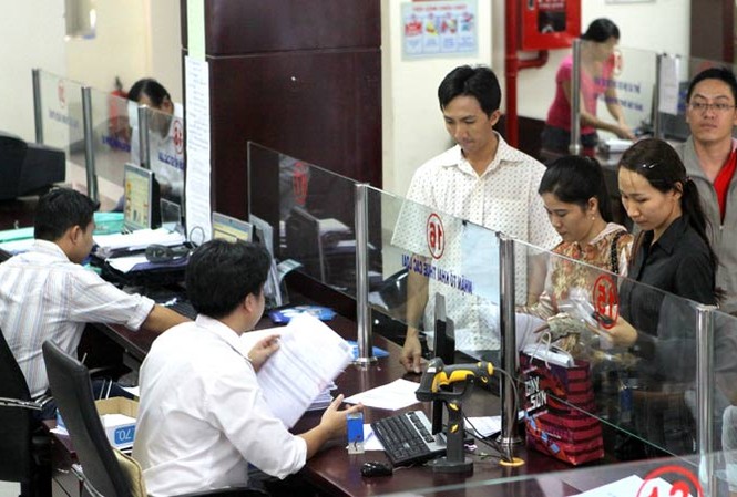 Tinh giản 1.336 công chức Tổng cục Thuế Cán bộ phòng Thuế Thành phố Hồ Chí Minh đang làm thủ tục nộp thuế của dân. Ảnh: Hồng Vĩnh.