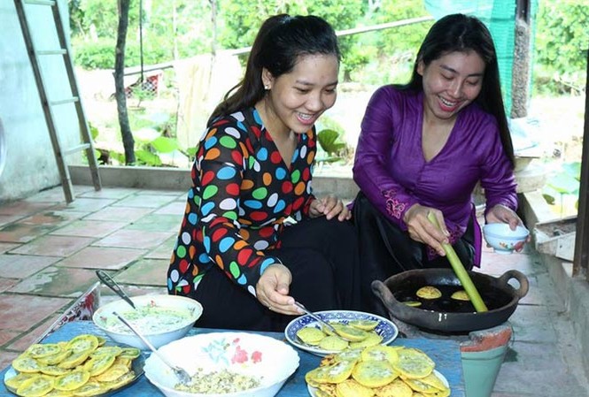 Bán cảm xúc cho du khách Nghệ nhân Lê Thị Bé Bảy (phải) hướng dẫn khách làm bánh. Ảnh: K. Mai.