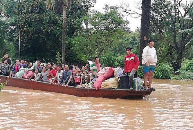 Vỡ đập thuỷ điện ở Lào: 15 gia đình Việt trong vùng ảnh hưởng Người dân vùng bị ngập lụt được đưa đi sơ tán bằng thuyền. Ảnh: Vientiane Times.