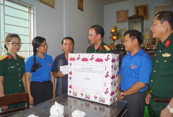 Tặng quà cho thương binh, mẹ liệt sỹ Thượng tá Ðinh Quốc Hùng, Trưởng ban Thanh niên Quân đội thăm hỏi, tặng quà cho thương binh Nguyễn Văn Chuyên. Ảnh: N.M.