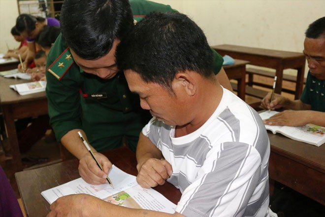 Lớp học đặc biệt nơi biên ải Trung úy Trần Thế Mạnh hướng dẫn học viên viết chữ trong một buổi học. Ảnh: B.S.