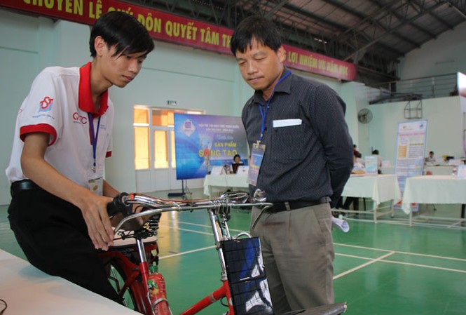 Sáng tạo thời 4.0 Mai Quốc Huy (bên trái) hướng dẫn sử dụng chiếc “xe đạp thông minh” của mình. Ảnh: NGÔ TÙNG.
