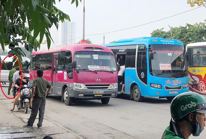 Công an đứng nhìn xe khách vi phạm Xe khách dàn hàng ngang bắt khách trên đường nhưng một cán bộ công an (vòng tròn) làm việc tại cổng bến Giáp Bát sáng 20/8 chỉ đứng nhìn.