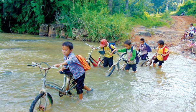 Sống tạm nơi rừng sâu Để đến trường cách xa nhà gần 10km, các em phải dắt xe lội qua nhiều con suối
