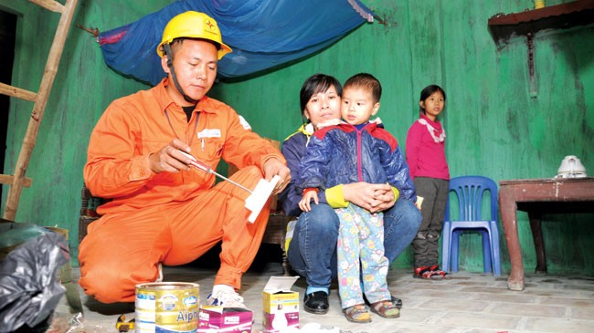 EVN góp phần thay đổi diện mạo nông thôn Nhân viên ngành điện sửa chữa điện miễn phí cho một hộ nghèo.