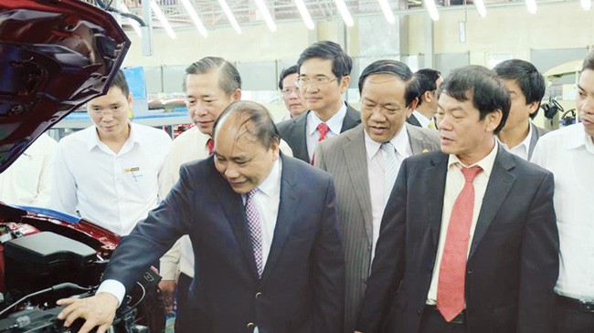 Kỹ sư Dương Ông Trần Bá Dương (bên phải) giới thiệu với Thủ tướng Nguyễn Xuân Phúc dòng xe mới tại Khu phức hợp ô tô Chu Lai. Ảnh: Hà Minh