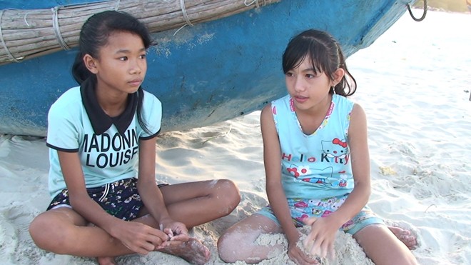 Chơi vơi khai trường Hai cháu Thơm và Hòa ngồi ngóng cha ngoài biển để vơi đi nổi nhớ mẹ đang làm thuê ở miền Nam.