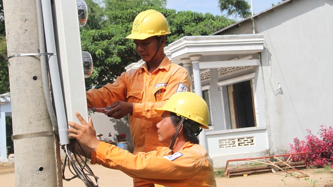 Điện về, đồng bào Khmer vui như hội Nhân viên Điện lực Duyên Hải gắn điện kế cho nhà dân tại ấp Ba Sát, xã Đôn Châu, huyện Duyên Hải, tỉnh Trà Vinh. Ảnh: Đại Dương