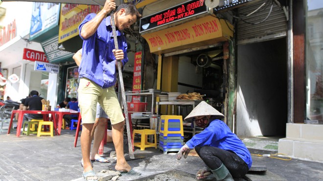 Vỉa hè Hà Nội: Thành phố yêu cầu lát đá, quận muốn lát gạch Công nhân Cty TNHH Thương mại và Xây dựng Quốc Thịnh sửa chữa tuyến phố Bà Triệu. Ảnh: Trường Phong