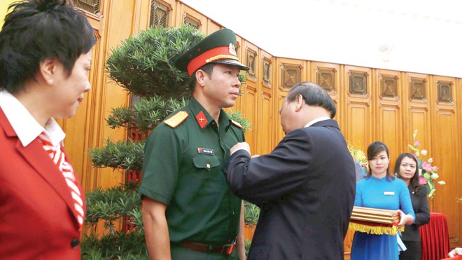 Cúp Chiến thắng vinh danh Hoàng Xuân Vinh Thủ tướng Nguyễn Xuân Phúc gắn tặng huân chương Lao động hạng Nhất cho Hoàng Xuân Vinh hồi tháng 8/2016. Ảnh: Như Ý