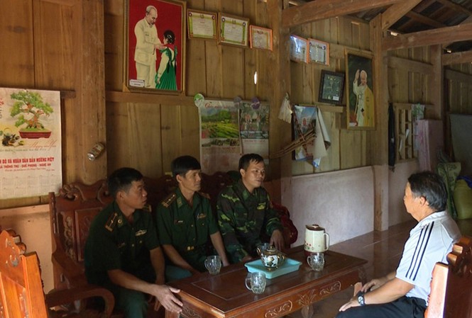 'Người bắc cầu' tình hữu nghị Thượng úy Nguyễn Văn Trinh (ngoài cùng bên phải) cùng đồng đội đang trao đổi công việc giúp đỡ người dân Lào với trưởng bản Nậm Táy. Ảnh: CTV.