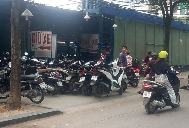 TPHCM: Quản chứ không dẹp bãi gửi xe Nhiều bãi giữ xe máy nội thành quá tải lấn chiếm vỉa hè làm nơi để xe. Ảnh: Ngô Bình.